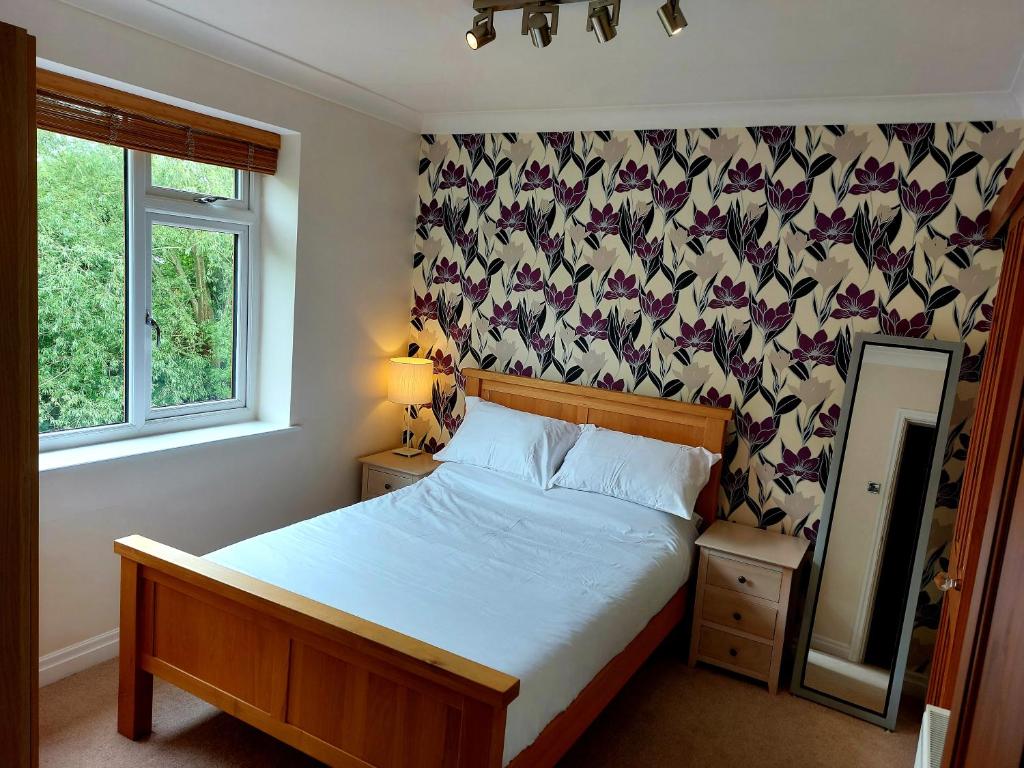 a bedroom with a bed and a window and a mirror at Riverside in York