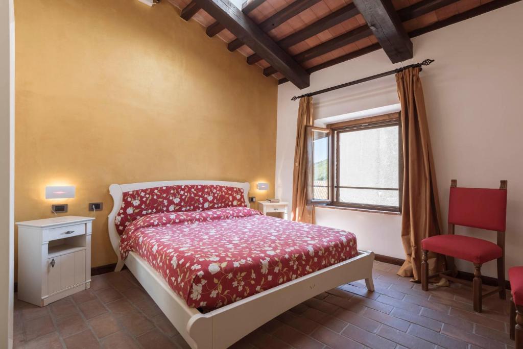1 dormitorio con cama, ventana y silla en Locanda La Luna, en Tirli