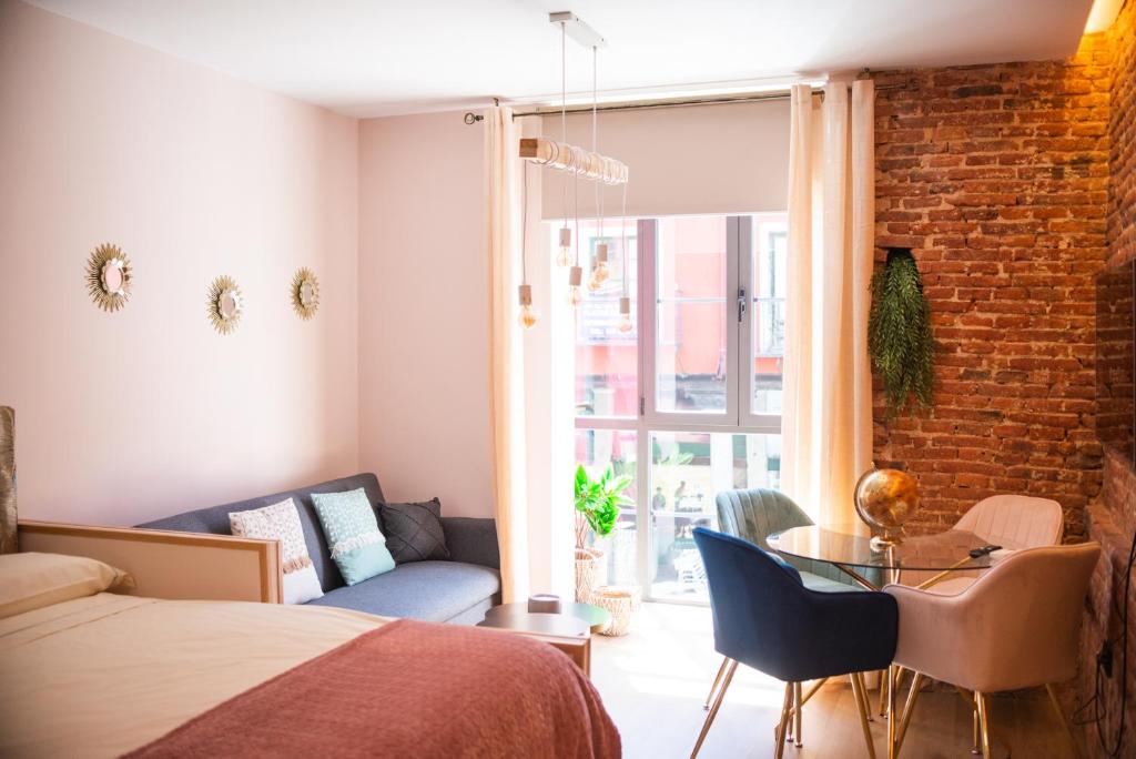 ein Schlafzimmer mit einem Bett und einer Ziegelwand in der Unterkunft Ferrari Suites in Valladolid