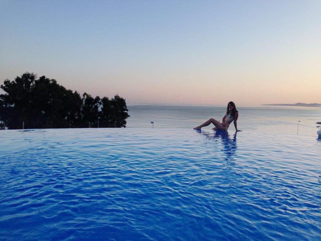 a woman sitting in the water in a swimming pool at SUNNY HOUSE AT THE BEACH infinity pool shared in Benalmádena