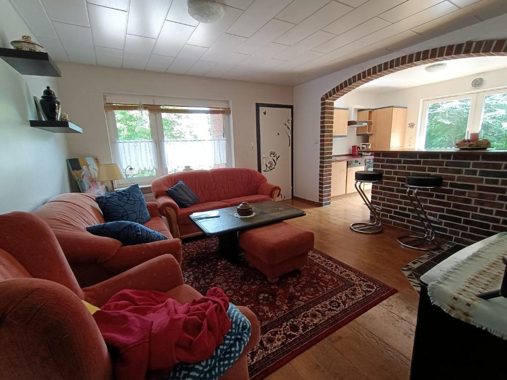 a living room with two couches and a fireplace at Old German Farm House, Appartement in Aurich