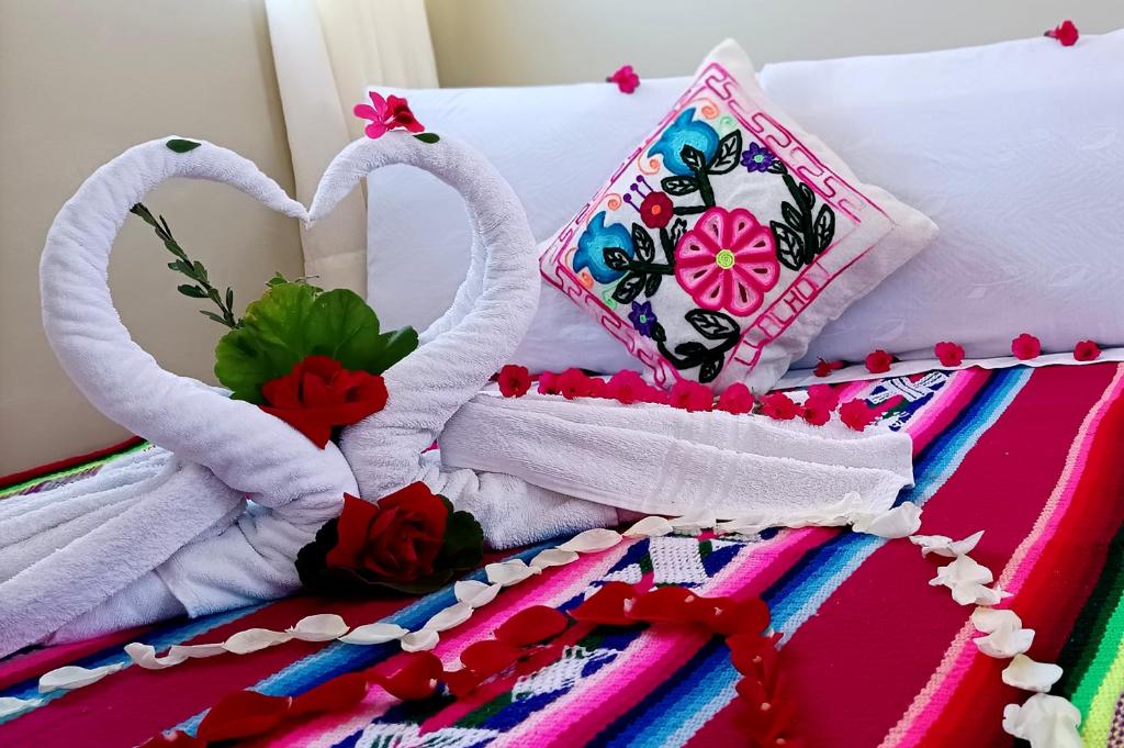 two white towel swans are made to look like hearts at Hospedaje Rural La Florida en Llachon, Titicaca in Puno