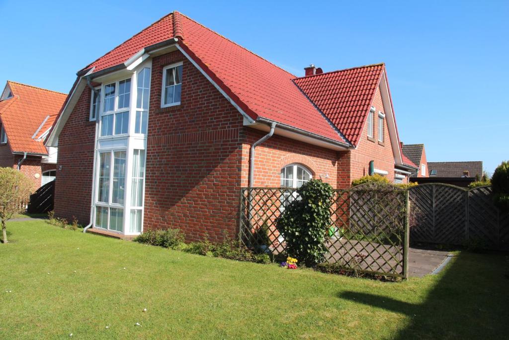 una casa de ladrillo marrón con techo rojo en Deichgraf, en Greetsiel