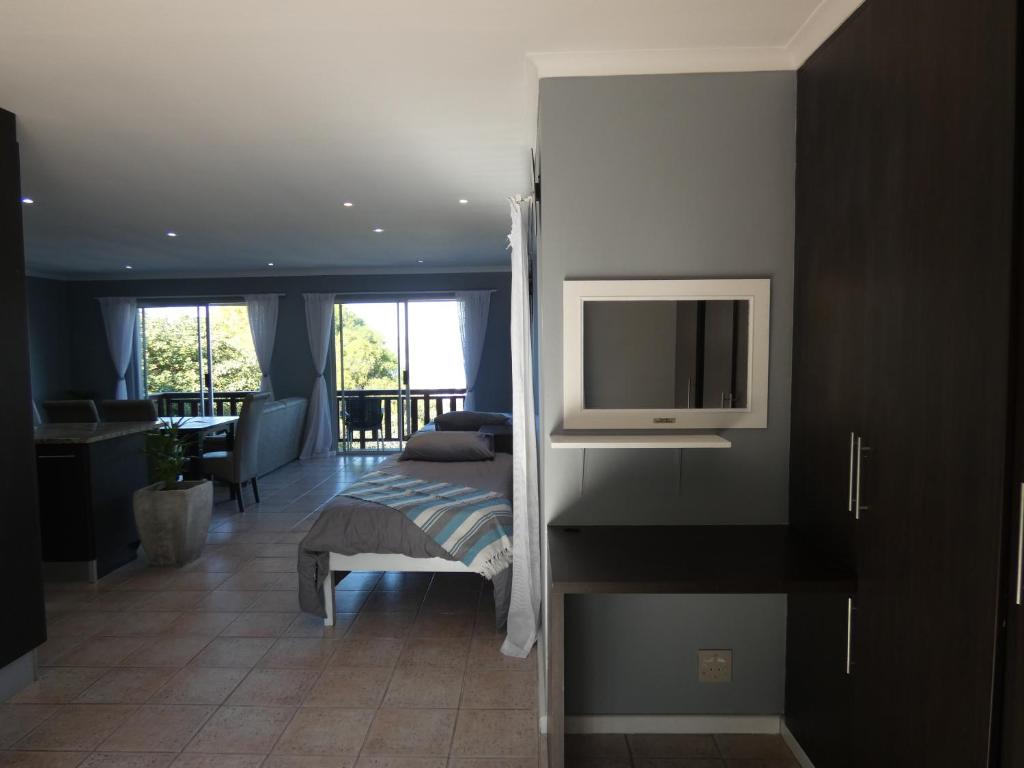 a bedroom with a bed and a tv on a wall at Knysna Lagoon View in Knysna