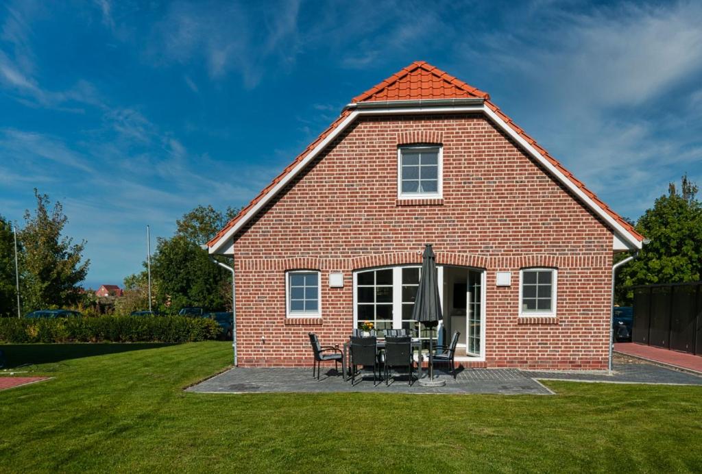 a red brick house with a table and chairs at Haifisch in Greetsiel