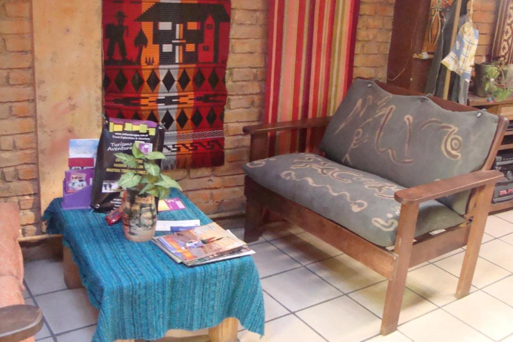 een stoel en een tafel met een tafelkleed bij Intiaconcagua Habitaciones Familiares in Ciudad Lujan de Cuyo