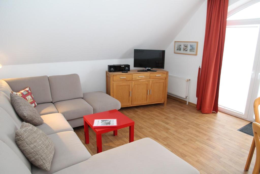 a living room with a couch and a tv at Möwennest in Norddeich
