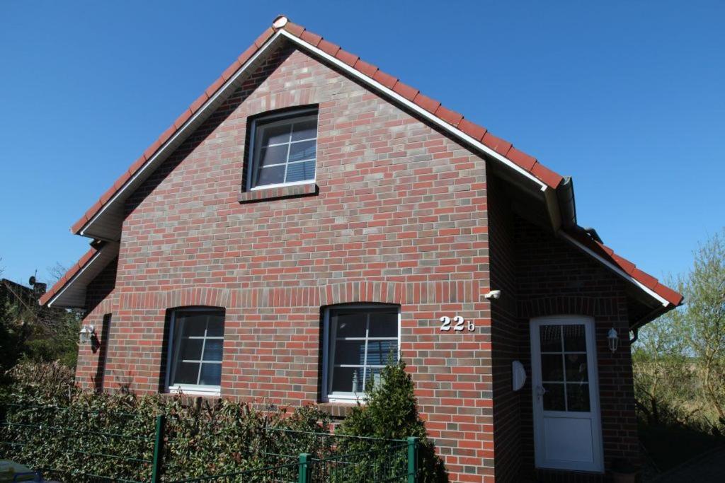 a red brick house with a white door at Deichbrise in Greetsiel