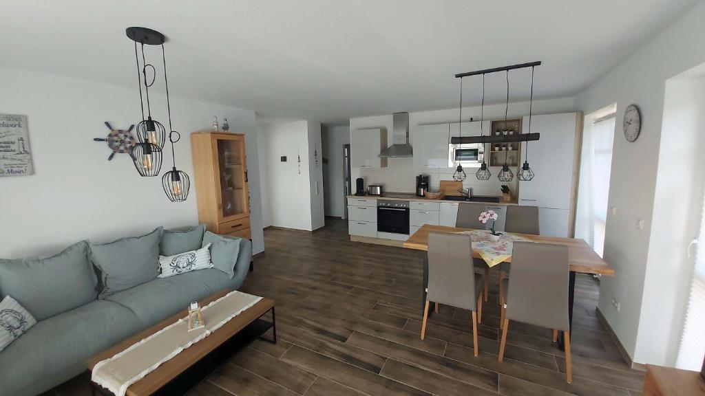 een woonkamer en een keuken met een bank en een tafel bij Grachtendrööm in Greetsiel