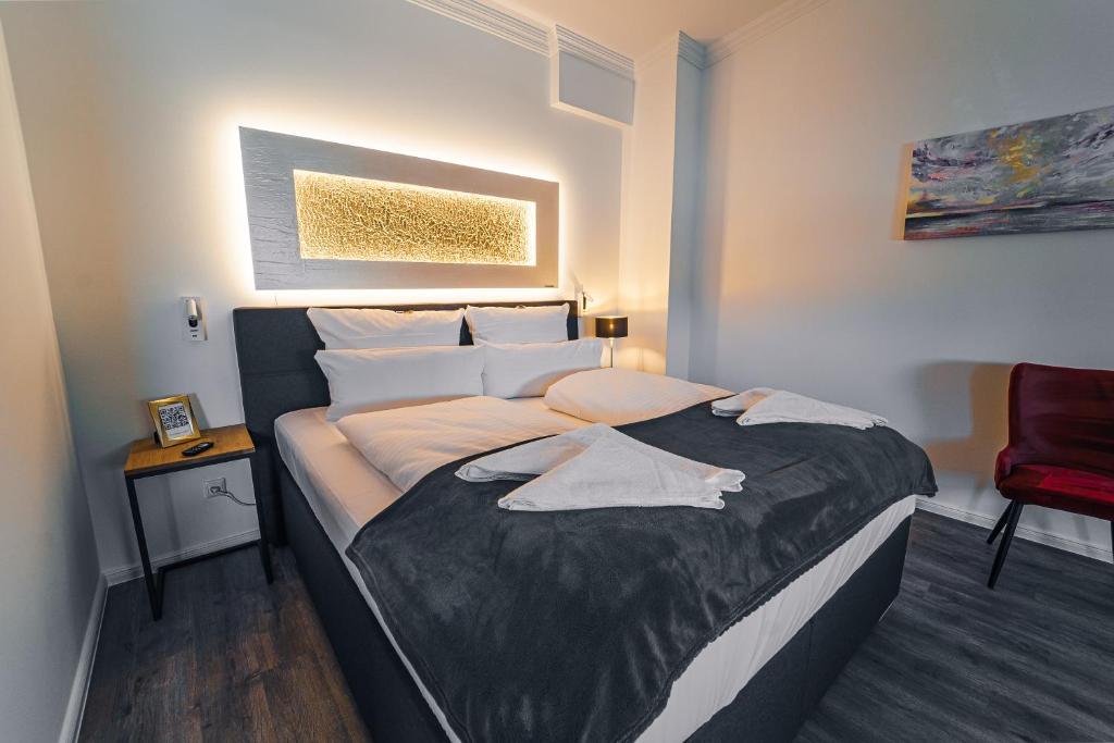 a large bed in a room with a red chair at Hotel Boutique am Schloss in Schleswig