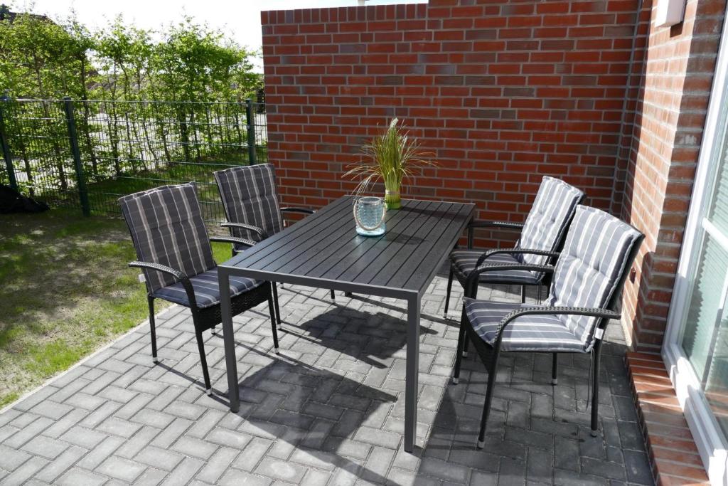 a black table and chairs on a patio at Wellenbrecher in Greetsiel