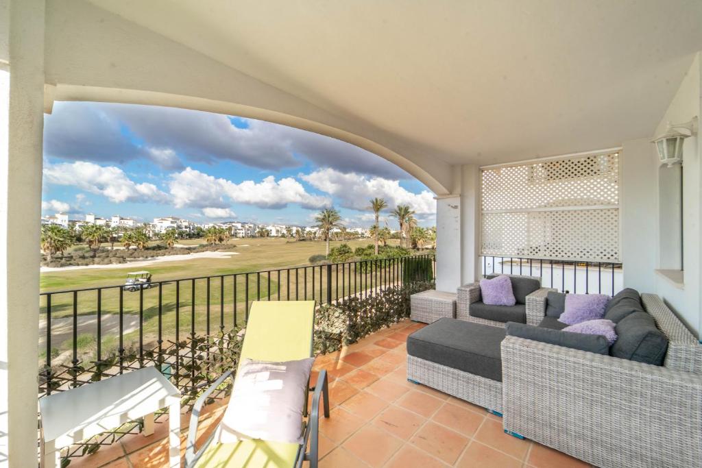 een balkon met een bank en een tafel en stoelen bij Nice Apartment With Large Terrace and Golf Views - RA1112LT in Torre-Pacheco