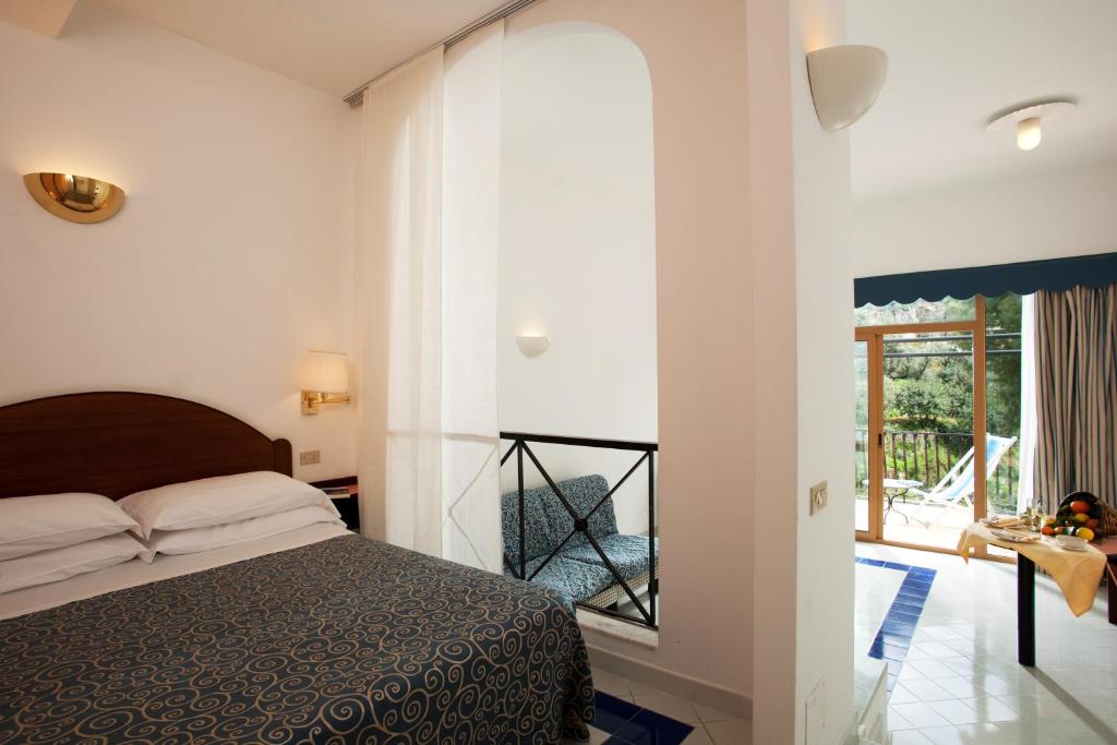 a bedroom with a bed and a large window at Hotel Royal Positano in Positano
