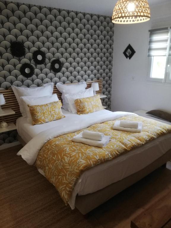 - une chambre avec un grand lit et 2 serviettes dans l'établissement Chambre d'Hôte Noalhat - Zenith d'Auvergne, à La Roche-Blanche