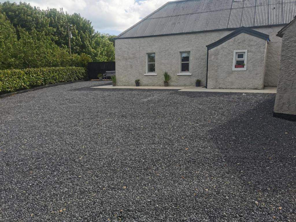 a house with a gravel driveway in front of it at Orchard Cottage in Wexford