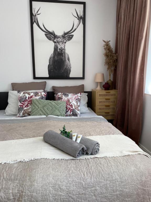 1 dormitorio con 2 camas y una foto de un ciervo en 7apartments en Jelenia Góra