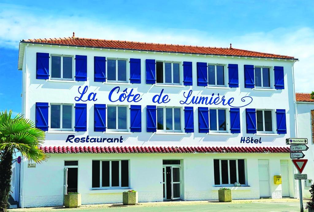 un edificio azul y blanco con un cartel en él en La Côte de Lumière, en La Tranche-sur-Mer