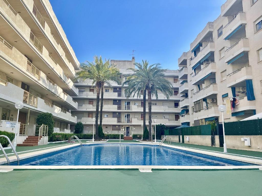 basen przed dużym budynkiem mieszkalnym w obiekcie La Pineda Holiday Apartment w mieście La Pineda