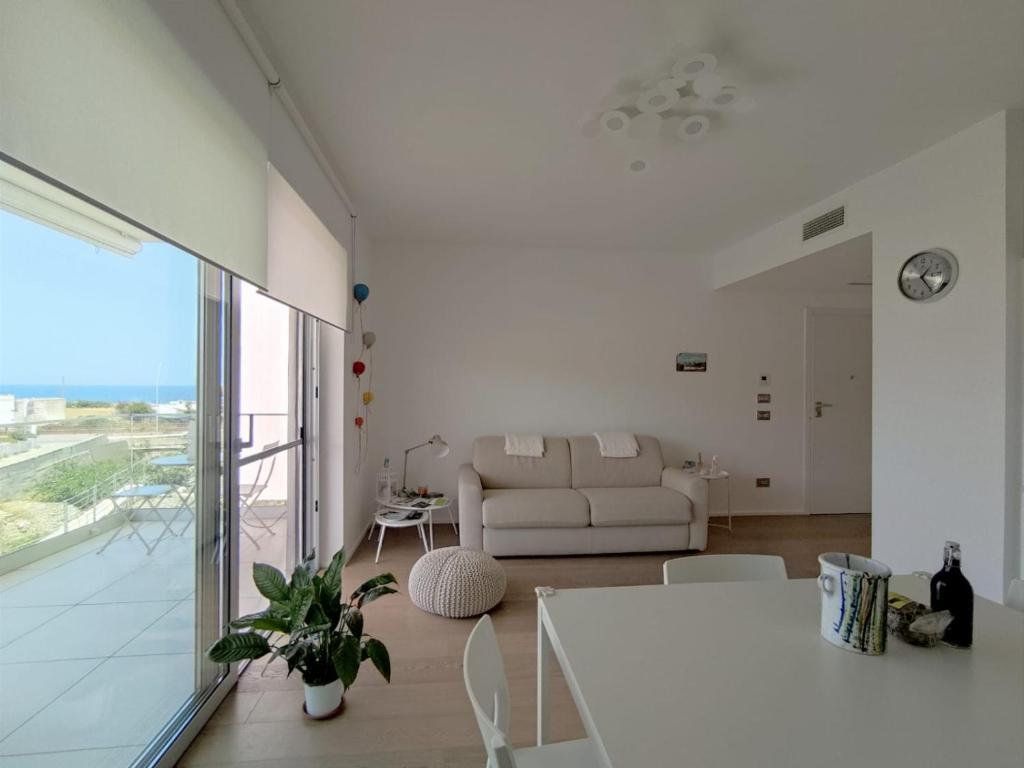 Sala de estar blanca con sofá y mesa en Dimora Birardi, en Polignano a Mare