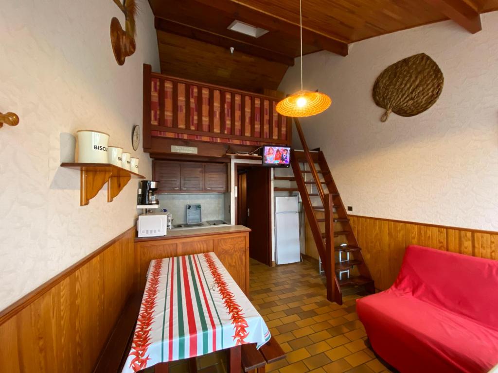 une cuisine avec un escalier et un canapé rouge dans une chambre dans l'établissement Mer du Sud, à Mimizan
