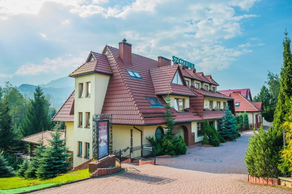 a large building with a red roof at Pensjonat Szczebel in Mszana Dolna