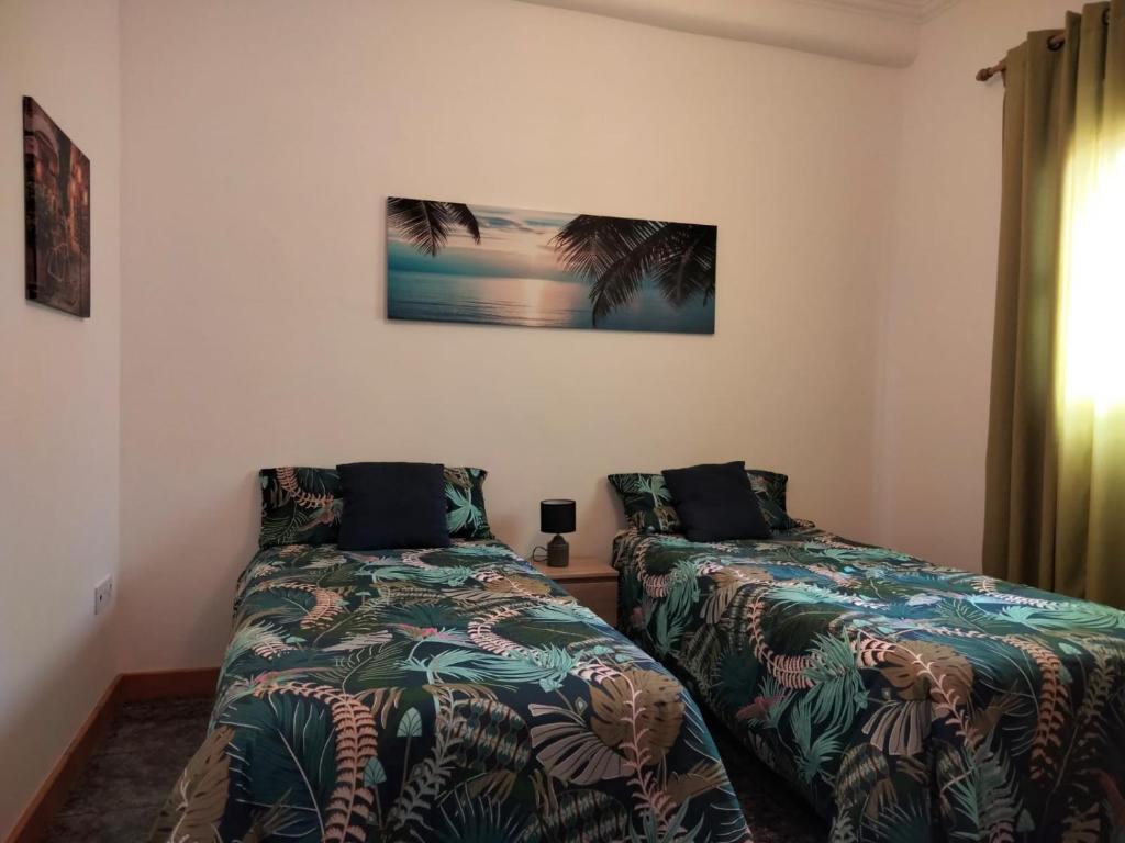 sypialnia z dwoma łóżkami i obrazem na ścianie w obiekcie APARTAMENTOS La PEÑA A w mieście La Guancha
