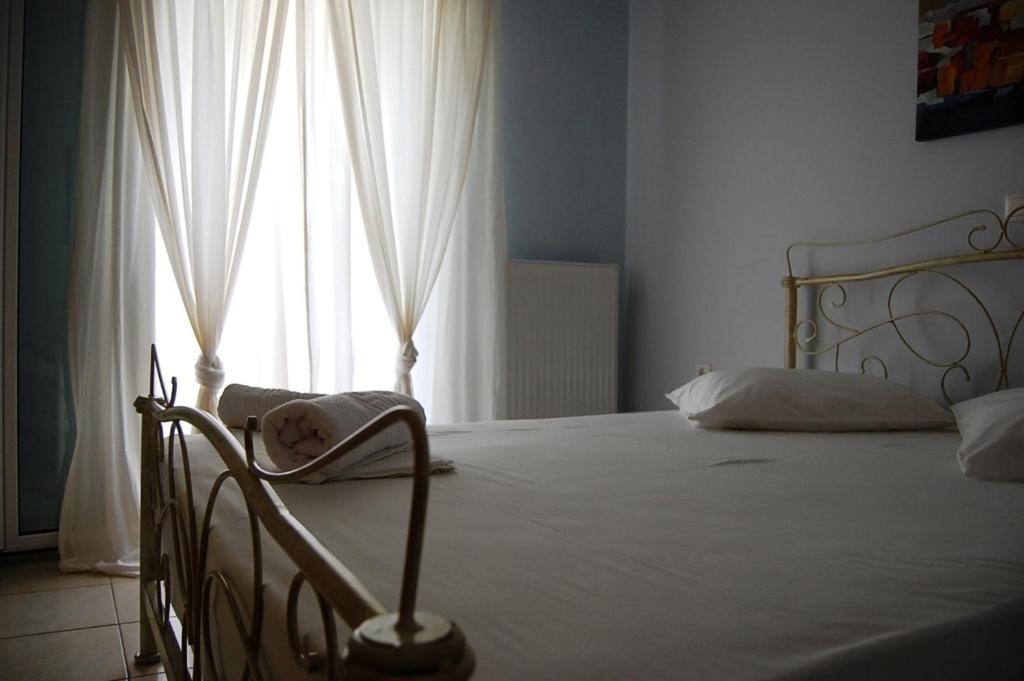 a bedroom with a bed and a large window at Morfi in Lefkada Town