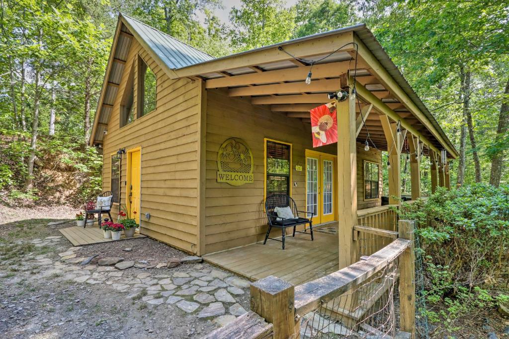a wooden cabin with a porch and a flag on it at Bumblebee Cottage Murphy Retreat with Hot Tub in Salem
