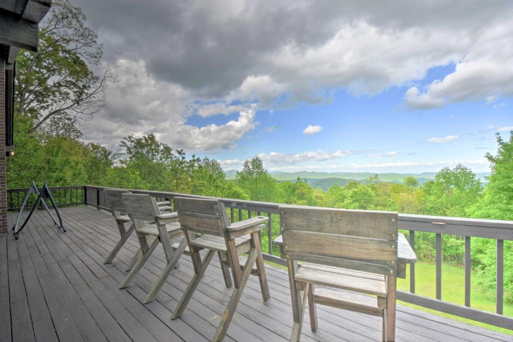 2 bancos de madera sentados en una terraza con vistas en Cabin with Balcony and Mtn Views Near Sky Valley!, en Dillard