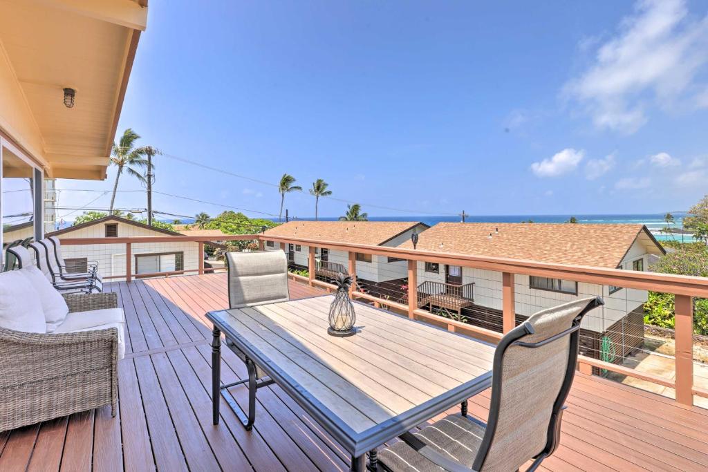 une terrasse en bois avec une table et des chaises. dans l'établissement Updated Poipu Home Large Deck with Scenic View, à Koloa