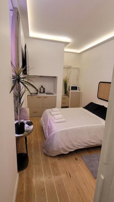 a bedroom with a white bed and a potted plant at Tiny Studio Rosa - Bairro Alto in Lisbon