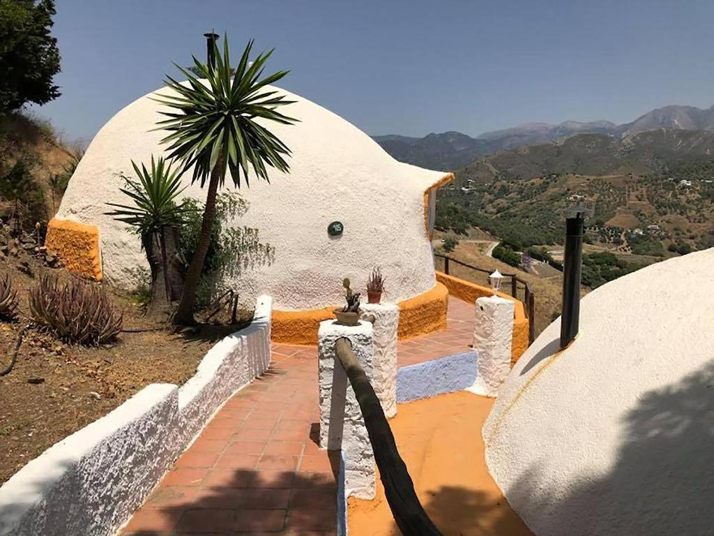 een koepelhuis met een palmboom op een heuvel bij Hotel Rural los Caracoles in Frigiliana