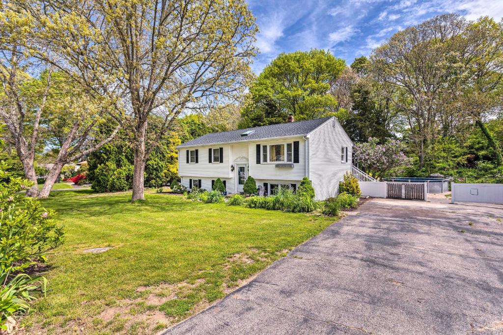 a white house with a driveway in a yard at Vibrant Westerly Home with Private Pool and Yard! in Westerly