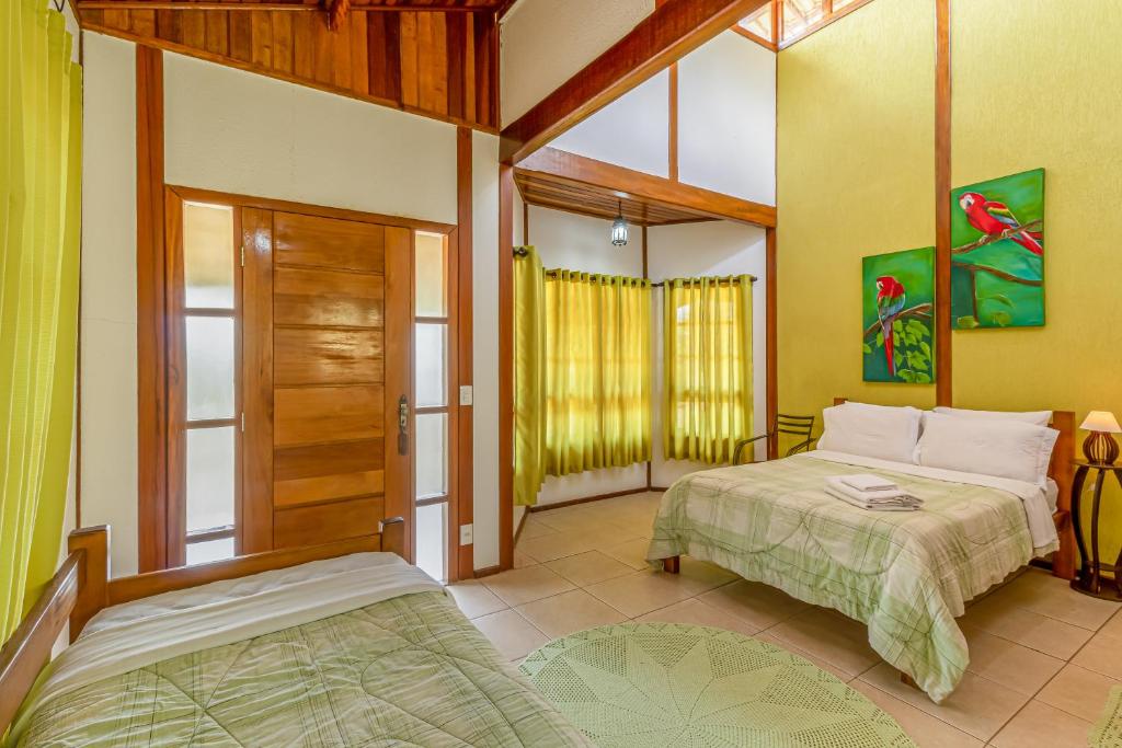 1 dormitorio con 2 camas y puerta corredera de cristal en Recanto Apoena en Santa Isabel