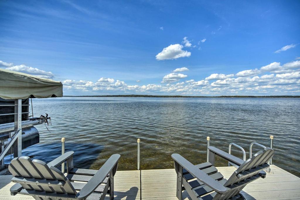 two chairs sitting on a dock next to the water at Waterfront Escape w/ Fire Pit in Crosslake! in Cross Lake