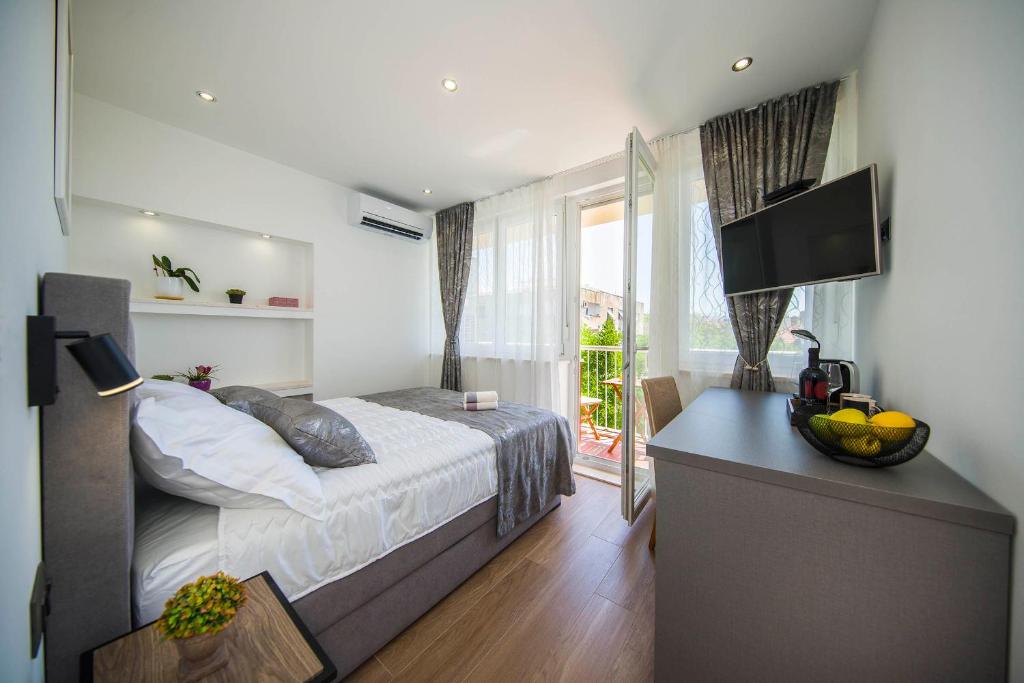 una camera con letto e scrivania con TV di Sunrise View Balcony a Spalato (Split)