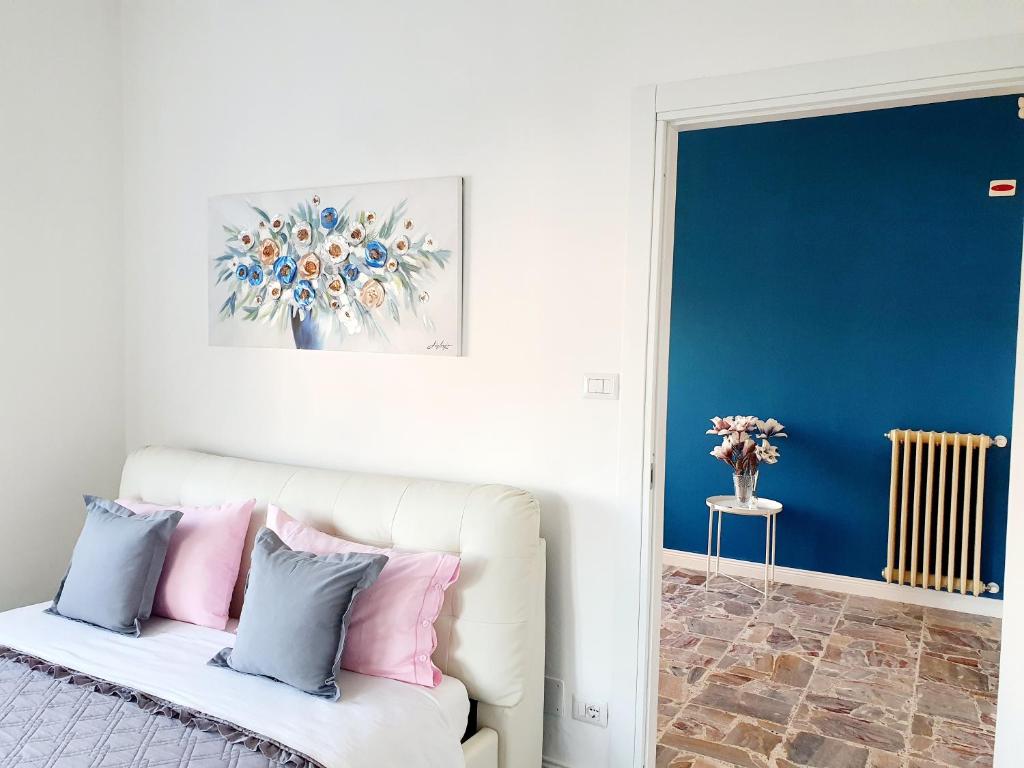 Un dormitorio con un sofá blanco con almohadas rosas y azules en Fiori e Frutti - Appartamento Accessibile, en Almese