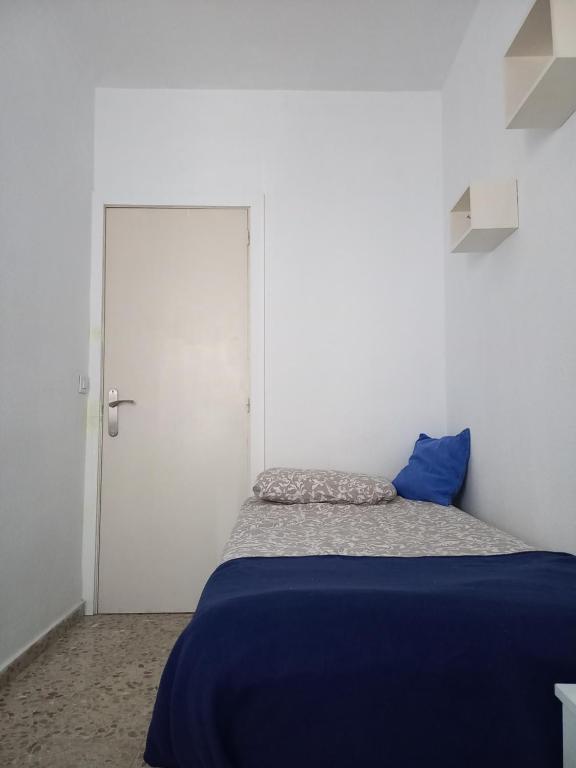 a bedroom with a blue bed and a white door at habitación en el centro in Santa Cruz de Tenerife