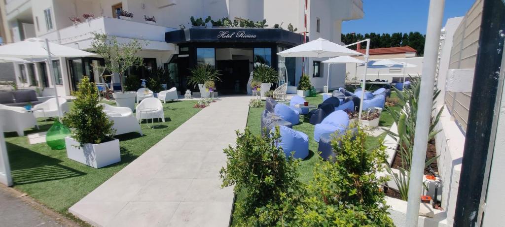 un gruppo di sedie e ombrelloni di fronte a un edificio di Hotel Riviera a Bari