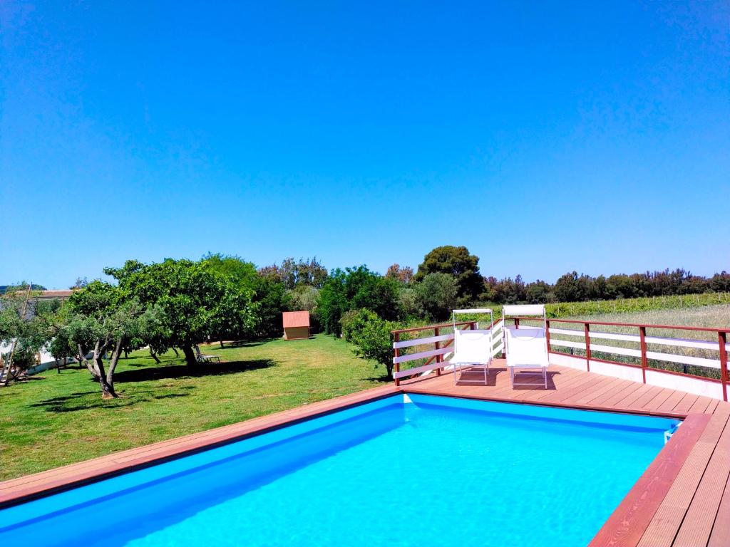 a swimming pool on a deck next to a fence at Podere Cala Viola in Porto Conte