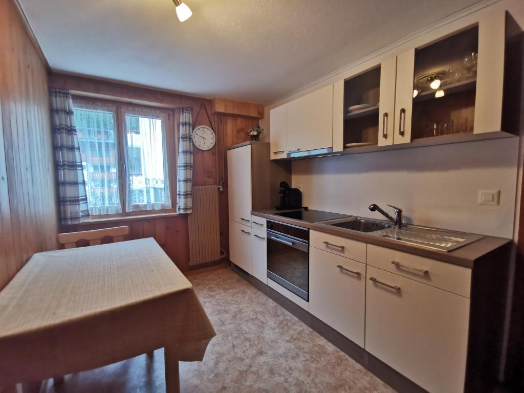 a kitchen with white cabinets and a sink and a counter at Apartment Alpenblick in Saas-Grund