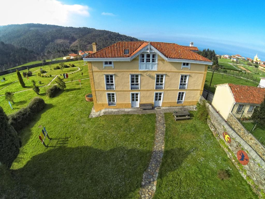 an aerial view of a large house on a green field at La Cochera de Somao, casona de tipología indiana in Somado