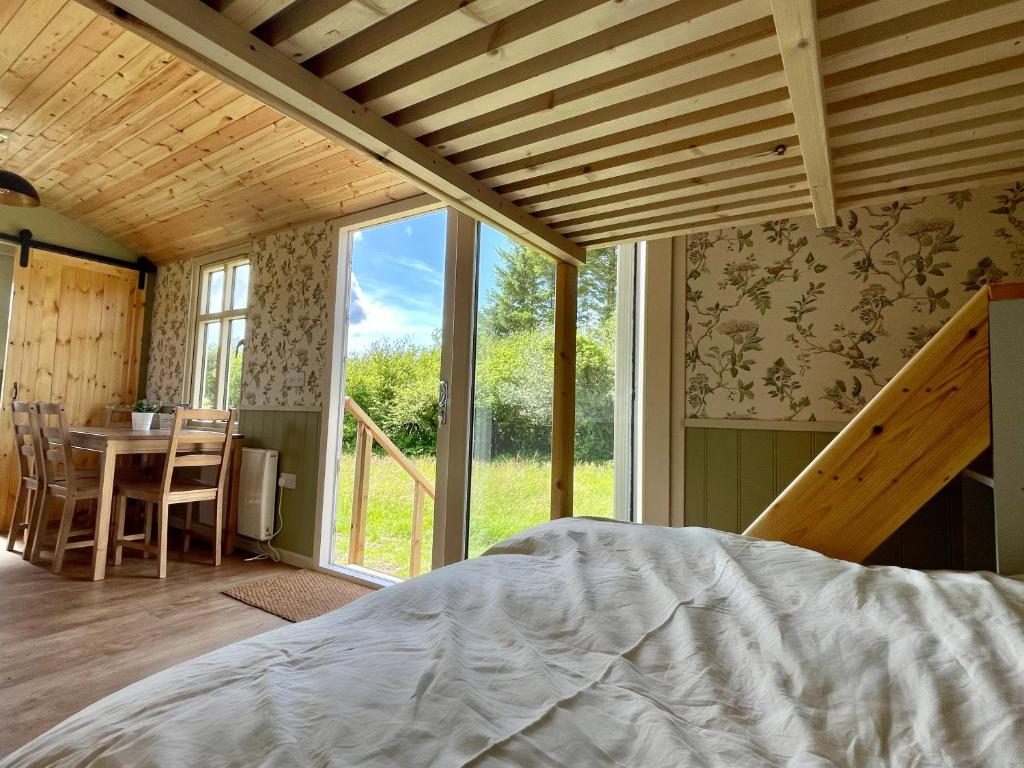 a bedroom with a bed and a table and a window at Stepping Stones Glamping ‘the olive’ in Bantry