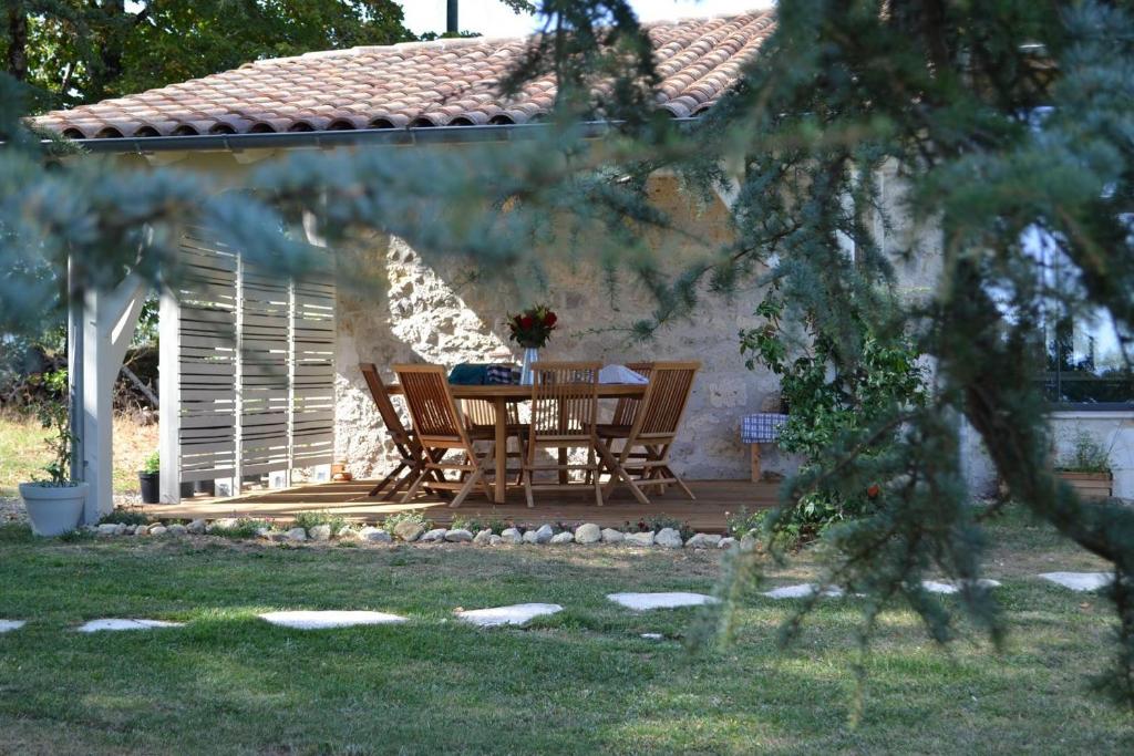a patio with a table and chairs in a yard at Chambre d’hôtes Mamounet Haut in Madaillan