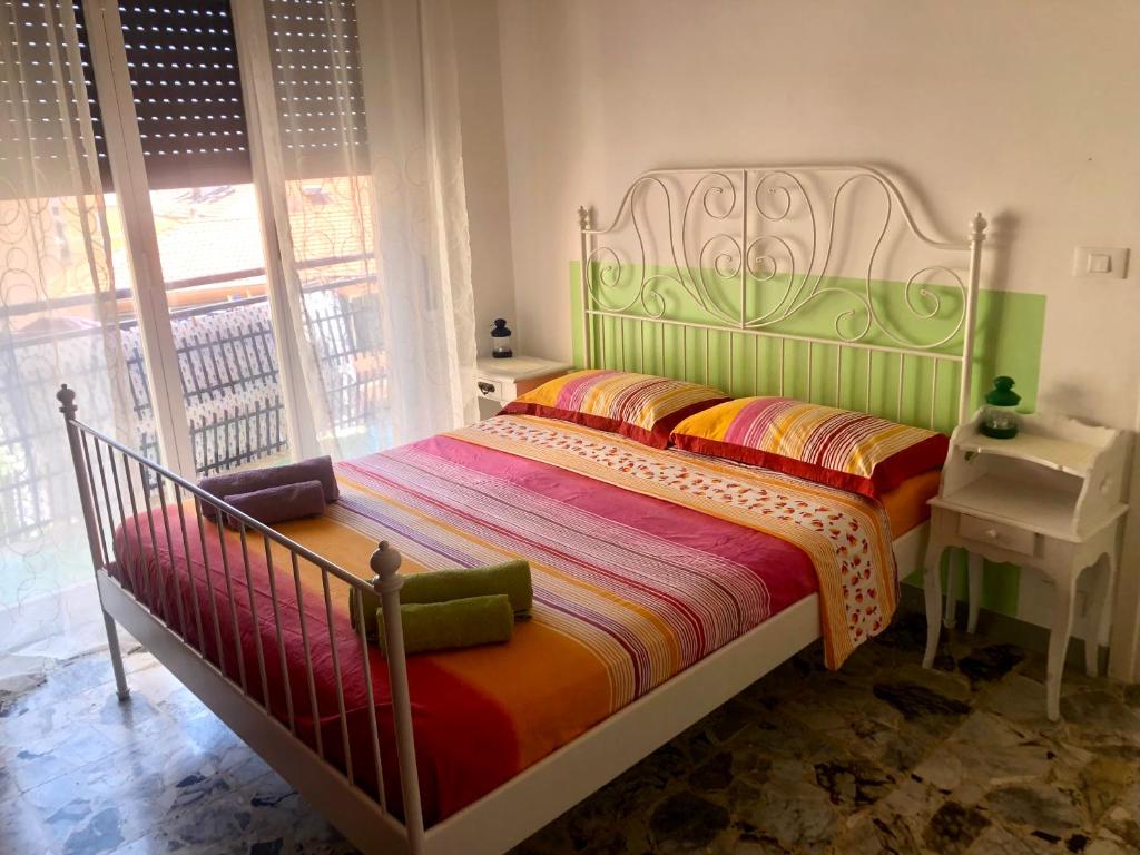 1 dormitorio con 1 cama en una habitación con ventana en Peaceful apartment 1 minute walk to the beach, en Ventimiglia