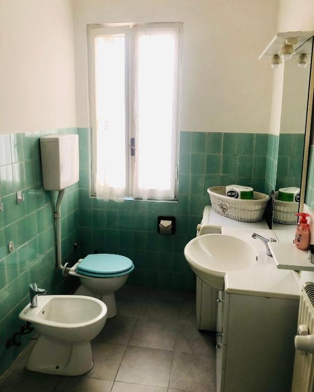 zieloną i białą łazienkę z toaletą i umywalką w obiekcie Peaceful apartment 1 minute walk to the beach w mieście Ventimiglia