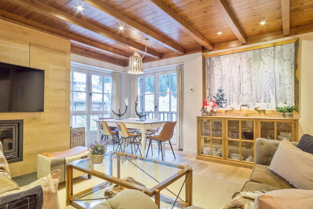 - un salon avec une cheminée et une table avec des chaises dans l'établissement Luderna - Apartamento Val de Ruda A19 de Saumet, à Naut Aran