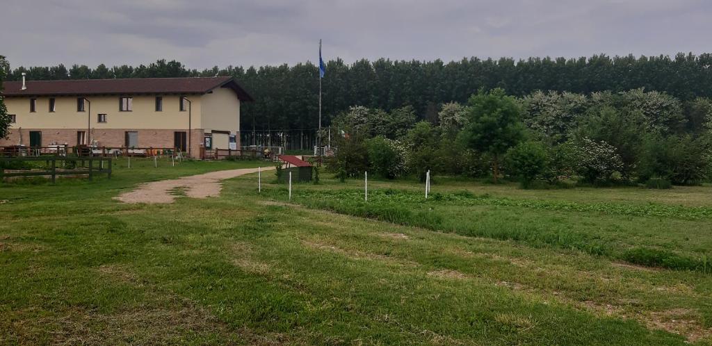 uma estrada de terra que leva a um edifício num campo em CASCINA LAI - Oasi Naturalistica - Camere private em Santena