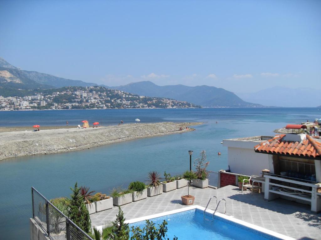 une maison avec une piscine à côté d'une étendue d'eau dans l'établissement Apartments Sutorina, à Herceg-Novi