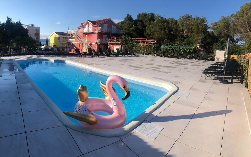 un flotador de flamenco rosa en una piscina en Lipovac resort Ficus, en Bilice